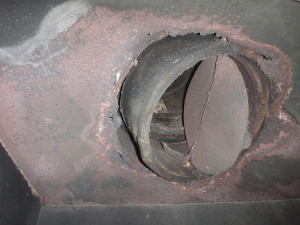 Rusted firebox where top of fireplace meets flue.
